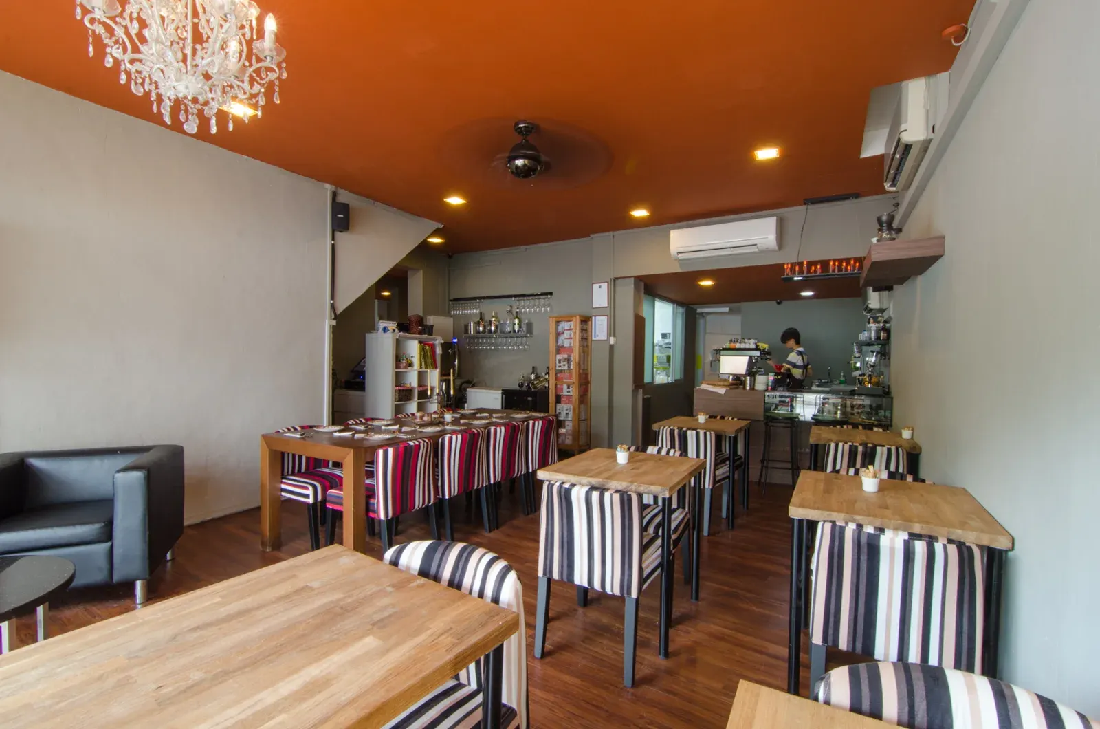Sun Ray Cafe dining room with striped chairs, wooden tables and wall-mounted air-conditioning